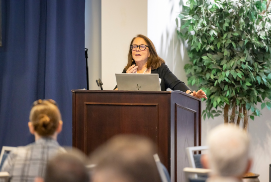 Susan Murin speaks behind a podium at the Rev PC Summit.