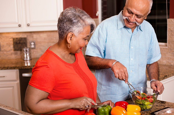 A couple working together in a kitchen.