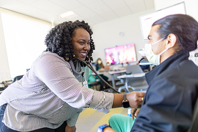 Psychiatry residents Calvin Tran and Monique Waltman helping medical students while on rotation in neurology.