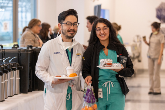 Two residents with plate breakfast from thank-you event.