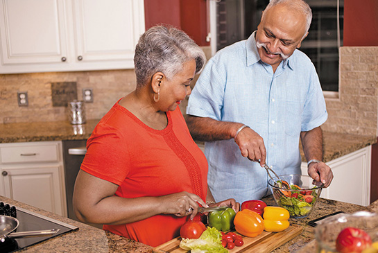 A couple working together in a kitchen.