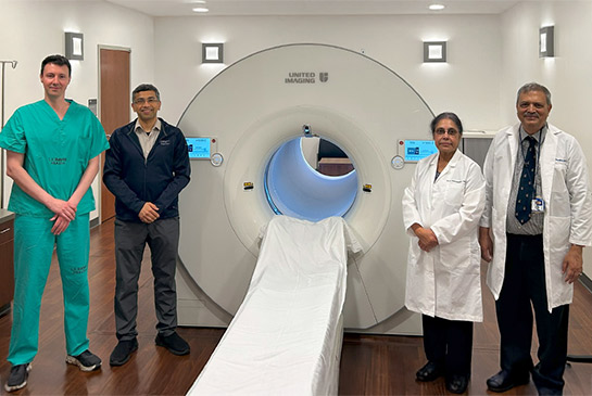 UC Davis Health team members standing next to PET scanner.