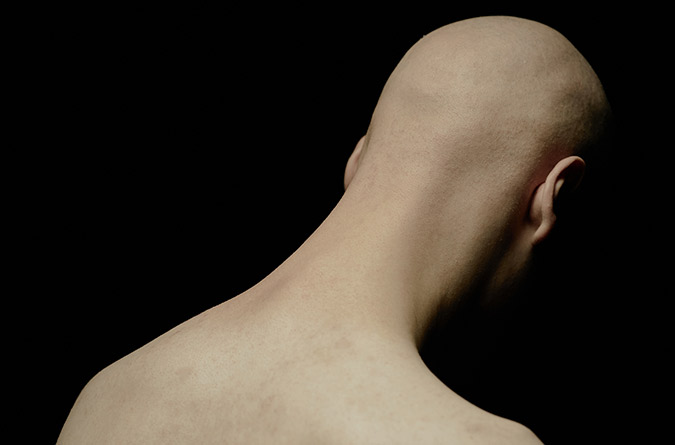 Person with shaved head and bare neck