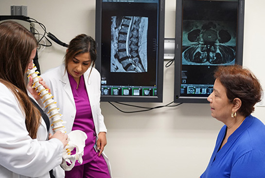 Care team shows patient spine model