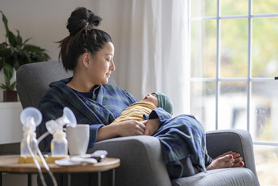 breastfeeding mother with pumped milk and baby