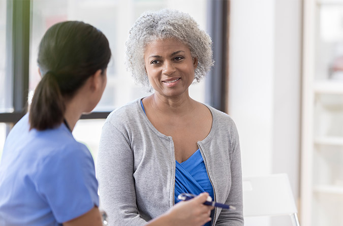 Clinician sitting with female patient.