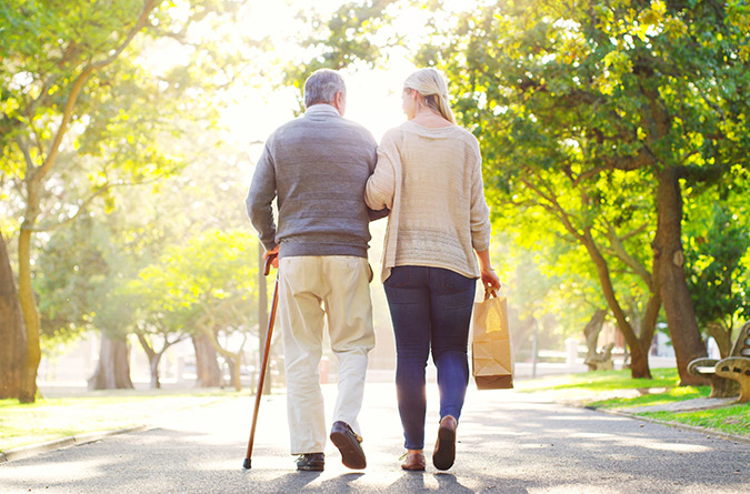 Elderly person walking with younger person