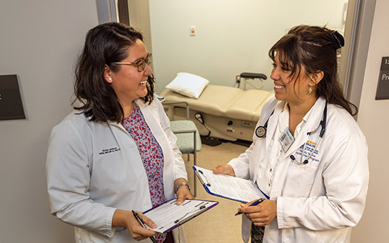 Two UC Davis Health geriatrics physicians holding clipboards.