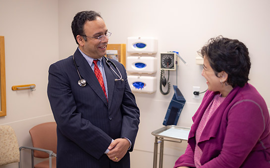 UC Davis Health rheumatologist Gaurav Gulati smiling at a patient.