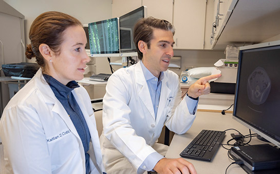 UC Davis Health urology specialists Kaitlan Cobb and Noah Canvasser looking at a computer.