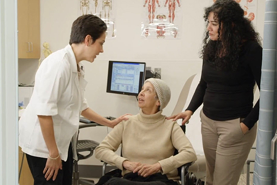 Healthcare workers assisting an elderly patient.