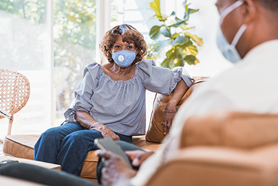 A man and woman sitting on a sofa having a discussion