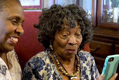 Two women teleconferencing using a phone