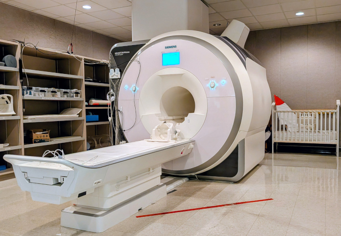 Researchers reviewing MRI scans on several computer screens.