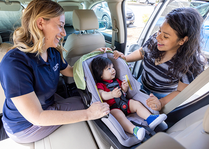Parents and an instructor installing car seats.