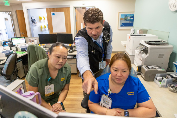 Doctor Stollenwerk reviewing chart with staff.