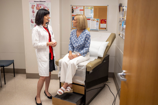 Doctor checking female patient's heart beat