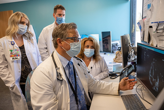 Doctors consulting about information they have about a patient while looking at a scanned image.