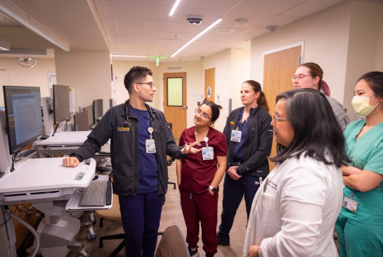 Hospitalists discussing something around a computer.