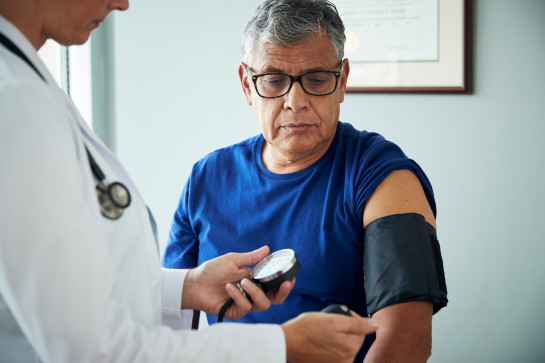 Doctor taking patient's blood pressure.