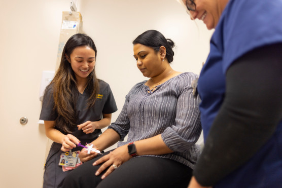 Nurse and provider assisting patient.
