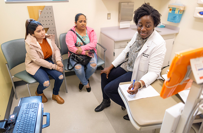 Dr. Oyebimpe Oluyemisi Adesina meeting with patients and an interpreter.