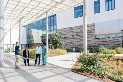 Four School of Medicine students having a discussion in a courtyard.