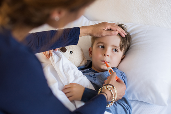 sick boy with thermometer