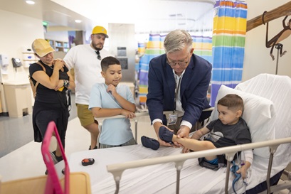 A physician interacts with a pediatric patient and his sibling in a hospital