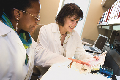 Two women reviewing paperwork in a laboratory.