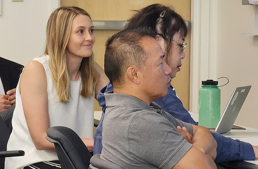 Four professionals sit together in a conference room.