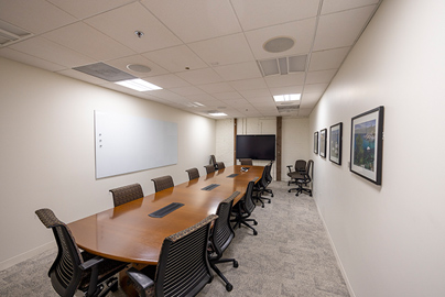 A meeting room with a long table and chairs.