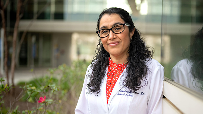 Alicia Gonzalez-Flores, M.D. Executive Director, ACE-PC & Rural ACE-PCP, leaning against building outdoors