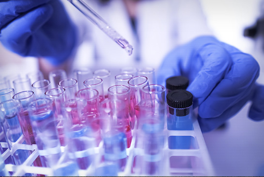 researcher with pipette filling test tubes