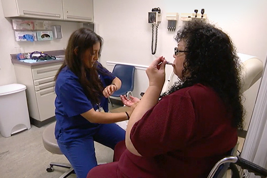 Medical student providing a check-up for a female patient in a clinic office