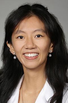 Portrait of medical student Mikayla Kwok in white coat and smiling