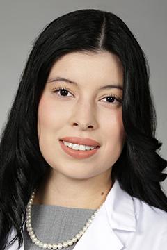 Portrait of medical student Alexis Mata in white coat and smiling