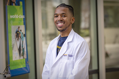 Medical student in front of UC Davis School of Medicine