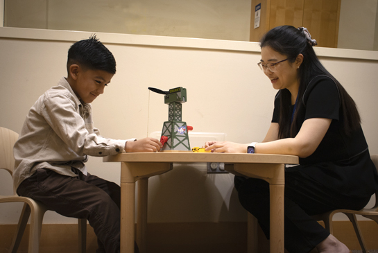 clinician playing with a child in a clinic room