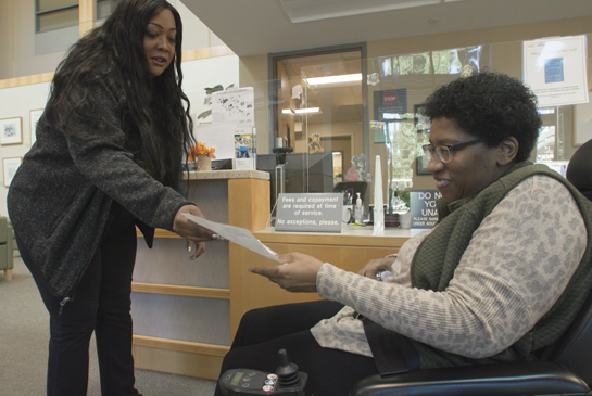 staff helping a patient with paperwork