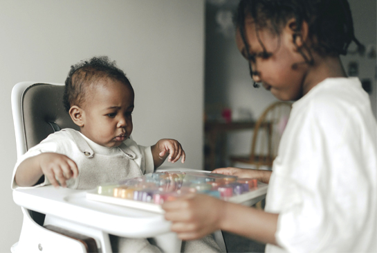 Young female patient playing with wooden toys smiles while in observation.