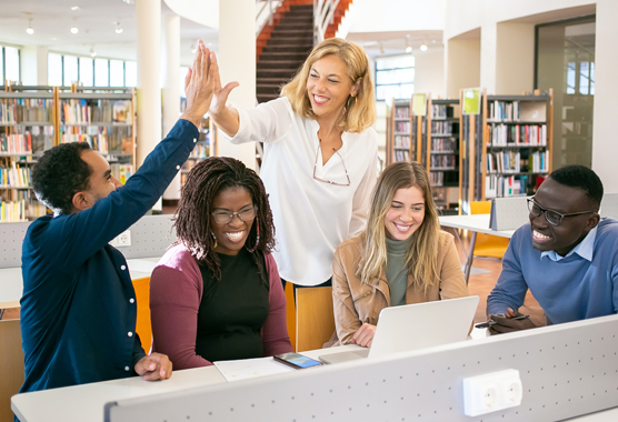 teens working with a coach in a library