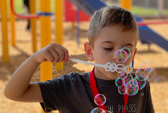 child blowing bubbles