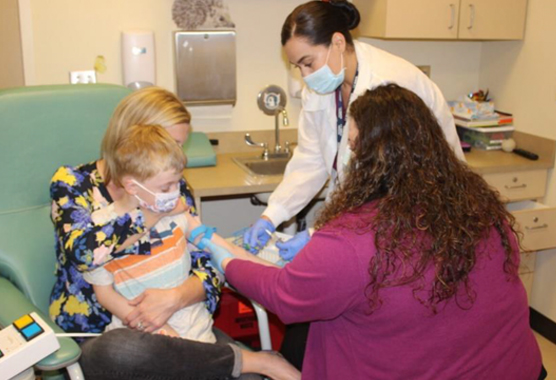 child getting his blood drawn with support