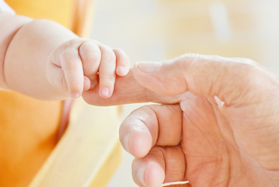 parent holding babys hand