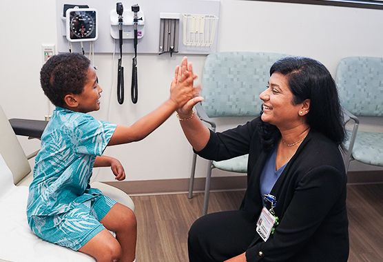 Doctor high fiving a pediatric neurology patient