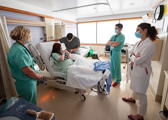 doctors and nurses talking with family in birthing center
