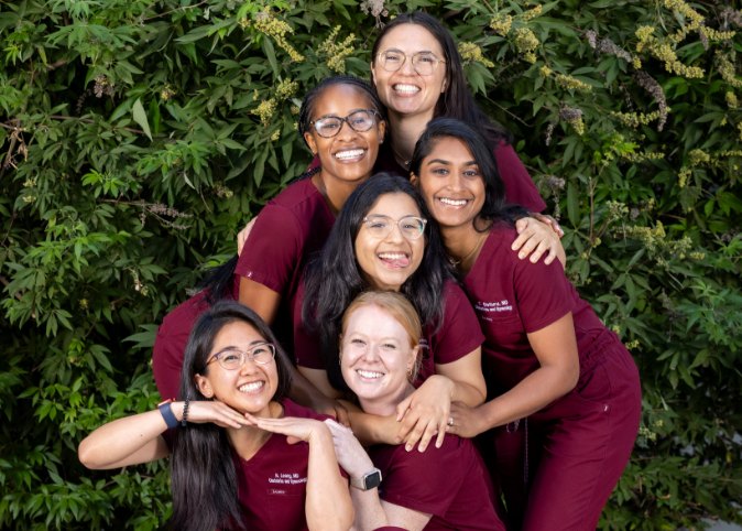 Female residents smile for a group photo outdoors.
