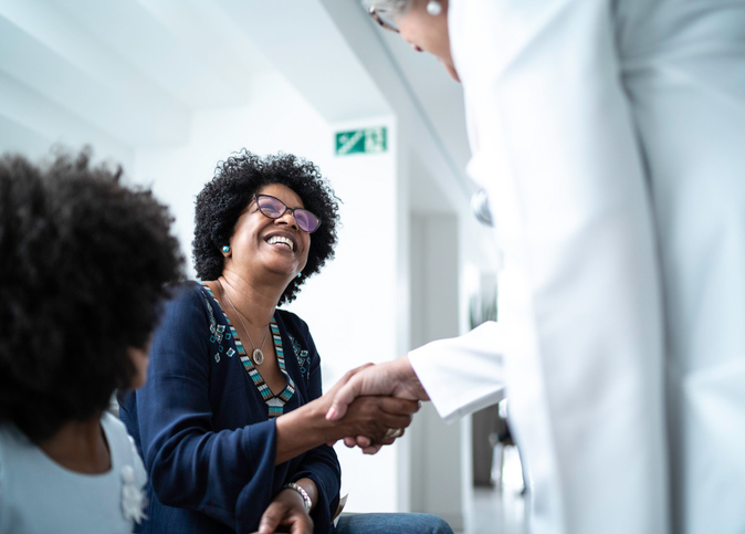 Patient and healthcare worker shaking hands 