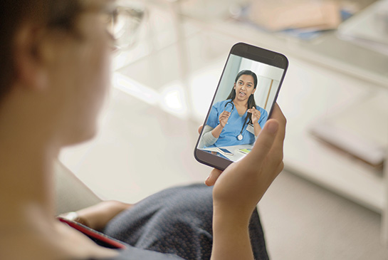 patient using a mobile phone to connect with and talk to provider